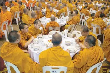  ?? — AFP ?? Buddhist monks eating during a royal ceremony at a government centre in Bangkok.