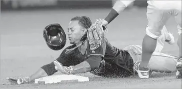  ?? Jayne Kamin-Oncea Getty Images ?? MICHAEL MARTINEZ of the Cleveland Indians is tagged out by Angels second baseman Johnny Giavotella while trying to steal second base in the sixth inning. Catcher Carlos Perez made the throw.