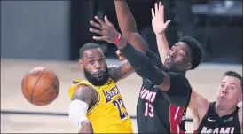  ?? MARK J. TERRILL— THE ASSOCIATED PRESS ?? Los Angeles Lakers’ Lebron James (23) passes the ballwhile pressured bymiami Heat’s Bam Adebayo (13) during the second half of Game 1of basketball’s NBA Finals Wednesday, in Lake Buena Vista, Fla.