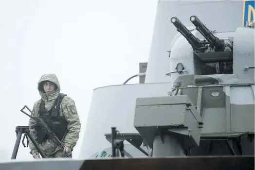  ?? PHOTO AFP ?? Un marin ukrainien monte la garde à bord d’un bateau militaire Dondass amarré à Marioupol, dans le port de la mer d’azov.