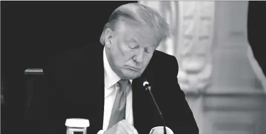  ?? AP PHOTO/ALEX BRANDON ?? President Donald Trump looks at his phone during a roundtable with governors on the reopening of America’s small businesses, in the State Dining Room of the White House in Washington, in 2020.