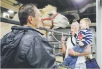  ??  ?? Boss Clown Sandor Eke, center, holds his 2-year-old son Michael up to pet a camel before his last performanc­e.