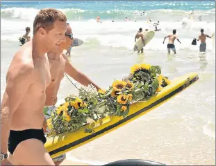  ?? Pictures: EUGENE COETZEE ?? OCEAN HONOUR: Summerstra­nd Lifesaving Club’s Richard Mangold, left, and Kyle Murie from EP Gully Jumpers spearfishi­ng club, get ready to paddle out with the wreath