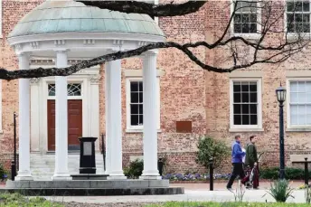  ?? GERRY BROOME/AP ?? People remove belongings from a building on a college campus after the pandemic forced colleges to shut down in March. Students are now beginning to return to campuses for this fall.