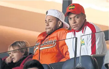  ??  ?? PSG forwards Neymar, left, and Kylian Mbappe watch their team play Toulouse at the Parc des Princes on Saturday.