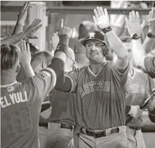  ?? Jae C. Hong / Associated Press ?? Astros rookie J.D. Davis, left, sports his jersey to commemorat­e the players’ weekend in the dugout after hitting a home run in the third inning of Friday night’s 3-2 win over the Angels.