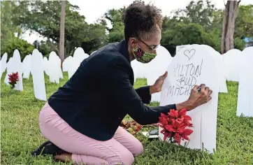  ??  ?? Cementerio simbólico creado para recordar y honrar la vida de quienes murieron por Covid-19 en el vecindario Liberty City en Miami