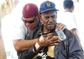  ?? Elizabeth Conley / Houston Chronicle ?? Kofi Taharka hugs Old Imperial Farm Cemetery guardian Reginald Moore on Sunday after Moore spoke outside the grounds where remains of what may be convict laborers were recently exhumed.