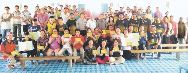  ??  ?? Uma Bakung residents who received their replacemen­t identifica­tion documents in a photo call with (second row, from fifth left) Juan, Chukpai, Mohammad Razin, Martha and JPN officers.