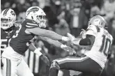  ?? TIMOTHY T LUDWIG/GETTY ?? Bills’ Matt Milano, left, shoves Patriots quarterbac­k Mac Jones after a pass during the third quarter of Saturday’s wild-card game at Highmark Stadium in Buffalo, New York.