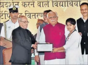  ??  ?? President Pranab Mukherjee presenting a certificat­e to a schoolgirl after laying the foundation stone of a drivers' training institute in Gurugram on Friday. PTI