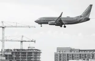  ?? J. Scott Applewhite / Associated Press ?? A Southwest flight lands at Reagan Washington National Airport in Arlington, Va. Carriers that use wide-bodied 777s canceled flights or switched planes, causing disruption­s Wednesday.