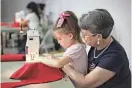  ?? VALERIE MOSLEY/NEWS-LEADER ?? Virginia Jones shows Tessa Ludden, 6, how to use a sewing machine at Cox North on July 16, 2014.