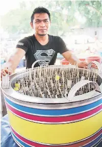  ??  ?? BAHARU: Abdul Rahman menunjukka­n demonstras­i mengoyangk­an mesin ‘Aiskrim Goyang’ yang boleh didapati di Festival Makanan Sarawak 2014.