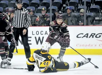  ?? BARRY GRAY/HAMILTON SPECTATOR ?? Peterborou­gh Petes' Alex Black moves the puck past a fallen Mackenzie Entwistle of the Hamilton Bulldogs during Sunday OHL action at FirstOntar­io Centre.