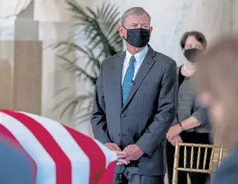  ?? Harnik, © The New York Times Co. Andrew ?? Chief Justice John Roberts and Justice Elena Kagan watch as the flag- draped casket of Justice Ruth Bader Ginsburg arrives at the Supreme Court for a special service last month in Washington.