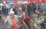  ?? AP ?? People dance as the Communist Party supporters wave red flags during a protest Saturday in the center of Moscow.