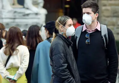  ??  ?? Una coppia di ragazzi con la mascherina in piazza della Signoria