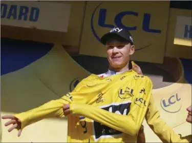  ?? PETER DEJONG — ASSOCIATED PRESS ?? Britain’s Chris Froome, puts on the overall leader’s yellow jersey on the podium after the eighteenth stage of the Tour de France cycling race over 179.5 kilometers (111.5 miles) with start in Briancon and finish on Izoard pass, France, Thursday.