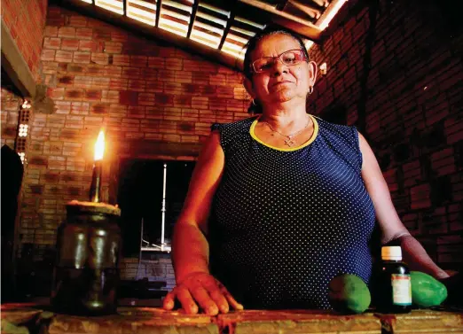  ??  ?? Sem luz. Da sua casa, em Crixás do Tocantins, Luzia de Souza vê as linhas de transmissã­o da usina de Belo Monte, mas depende da lamparina