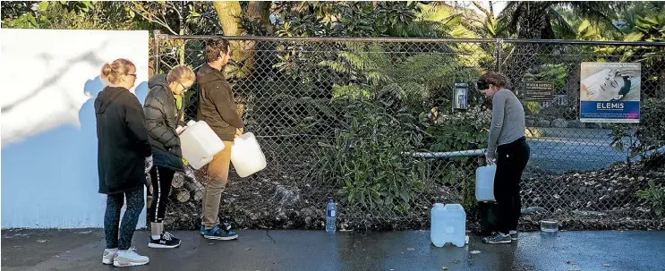  ?? DAVID WALKER/STUFF ?? A steady stream of Christchur­ch residents queue daily to fill bottles and containers at a free suburban well to avoid drinking the chlorinate­d water coming from their taps.