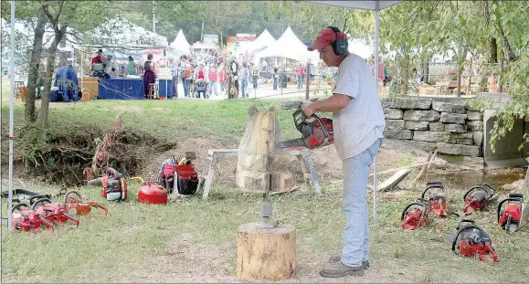  ?? Keith Bryant/The Weekly Vista ?? Chainsaw carver Scott Winford carves a hunk of wood into a bear during the Spanker Creek Farm Arts and Crafts Festival.