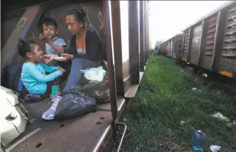  ?? Marco Ugarte / Associated Press ?? A migrant mother and children ride a freight train Monday in the Chiapas state town of Palenque. Mexico is trying to stem the flow of migrants traversing its territory to reach the U.S.