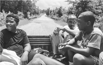  ??  ?? Young attendees of the annual retreat at New Medinah ride in the back of a pick-up truck to a nearby house with a swimming pool to escape the mid-day heat. — WP-Bloomberg photos