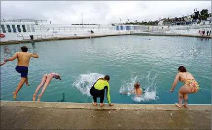  ?? Pictures: HUGH R HASTINGS/GETTY; JACOB KING/PA ?? Swimmers dive – and jump – into Jubilee Pool, an open-air seawater lido in Penzance, Cornwall