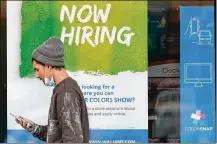  ?? TONY DEJAK/ASSOCIATED PRESS ?? A man walks past a “Now Hiring” sign at Sherwin Williams store in Woodmere Village, Ohio. Jobless claims have hit their lowest point since the pandemic began.