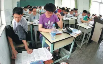  ?? WANG CHUANYUAN AND XU QING / FOR CHINA DAILY ?? Above: Peng Chao, a disabled student from Sichuan province, uses his feet to write notes as he prepares to take the a double amputee from Sichuan, is carried from the exam room by her father.