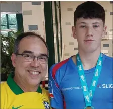  ??  ?? Anthony Maher with Head Coach Eduardo Sligo Swimming Club receiving his gold medal in the 200IM at Division 2 swim gala held recently in UL. Anthony came home with 5 medals in total. One gold. two silver (100 back/200 brst) and two bronze for relays.
