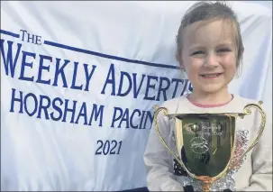  ??  ?? ALL SMILES: Willow Tonkin, 6, the daughter of Emma Stewart who trained 2021 Horsham Pacing Cup winner Mach Dan, proudly shows off the winning cup. Picture: DEAN LAWSON