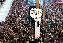  ?? AP ?? Anti-government protesters in Beirut, Lebanon, reinstall a new large cardboard fist labeled ‘Revolution’ in Martyr’s Square.