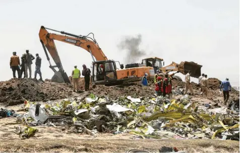  ?? Foto: Michael Tewelde, afp ?? Überreste des Flugzeugwr­acks der Ethiopian Airlines am Absturzort in der Nähe von Bishoftu südlich von Addis Abeba. Kurz nach dem Start hatte der erfahrene Pilot noch einen Notruf abgesetzt. 157 Menschen starben in den Trümmern, darunter fünf Deutsche.