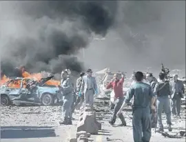  ?? Photograph­s by Shah Marai AFP/Getty Images ?? SECURITY FORCES gather at the site of a bombing in Kabul. The blast shattered windows as far as a mile away and left a crater more than 30 feet deep.