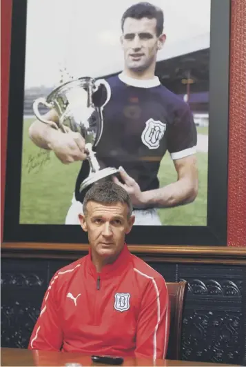  ??  ?? 0 Jim Mcintyre in front of a photo of Dundee legend Bobby Cox with the league championsh­ip trophy.