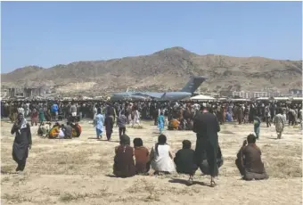  ?? AP PHOTO/SHEKIB RAHMANI ?? Hundreds of people gather near a U.S. Air Force C-17 transport plane Aug. 16, 2021, at the perimeter of the internatio­nal airport in Kabul, Afghanista­n.