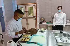  ??  ?? Rabbi Yaakov Eisenstein (right) supervises the preparatio­n of food Elli’s Kosher Kitchen, in Dubai.