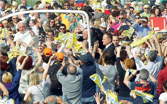  ??  ?? Papamobile Bergoglio arriva al Parco di Monza (foto sopra) dove ieri ha celebrato la messa davanti a oltre mezzo milione di persone. Qui a destra, il Papa al pranzo con i detenuti di San Vittore. Poco prima ha preso in mano per strada, in via Orefici,...