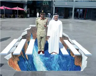  ?? Supplied photos ?? Major-General Abdullah Khalifa Al Marri and Mattar Al Tayer check out a 3D painting on pedestrian crossing as part of the GCC Traffic Week activities in Dubai on Sunday. —