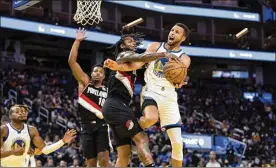  ?? JOHN HEFTI / AP ?? Stephen Curry, who is fouled by the Blazers’ Ben McLemore on a layup, is best known scoring 3-pointers. He is only 141 behind eclipsing Ray Allen’s all-time mark.