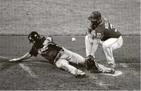  ?? Jamie Squire / Getty Images ?? The Astros’ Myles Straw scores on a wild pitch in the seventh inning as Royals reliever Greg Holland attempts to cover the plate.