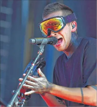  ??  ?? ASSOCIATED PRESS Twenty One Pilots frontman Tyler Joseph dons goggles as he performs Sunday at Lollapaloo­za in Grant Park in Chicago. The band attracted an enormous crowd.