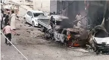  ?? Militant photo via Associated Press ?? A photo posted online Thursday by supporters of the Islamic State shows Syrian citizens near burned cars after airstrikes hit Manbij, a city in Syria’s Aleppo province.