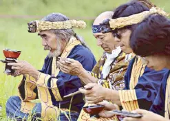  ?? EPA ?? Shinrit Eoripak Ainu Kawamura (left) holds a cup filled with sake during a blessing ceremony at a campsite in Date, Hokkaido, Japan in this file photo.