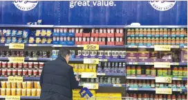  ?? (Phil Noble/Reuters) ?? A CUSTOMER looks at products on a shelf inside a Tesco Extra superstore near Manchester.