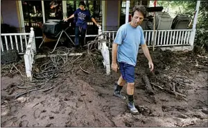  ?? AP/BRENNAN LINSLEY ?? Allen Tawa and his daughter Kayla, 17, step out of their flooded house Saturday on the southern edge of Boulder, Colo. Authoritie­s warned some residents to evacuate or face weeks without basic services.