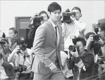  ?? Koji Sasahara Associated Press ?? SHOHEI OHTANI, a two-way star in Japan, announces at a news conference Saturday in Tokyo his desire to play in the major leagues. The Dodgers are among several teams expected to pursue the pitcher and hitter.