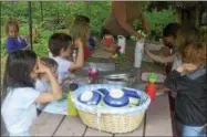  ?? PHOTO BY JOSEPH PHELAN — JPHELAN@DIGITALFIR­STMEDIA.COM ?? The campers gather around a picnic table to eat oatmeal with raisins.